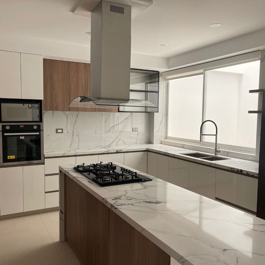 Cocina moderna con isla central en melamina blanca y cuarzo — San Isidro, Trujillo